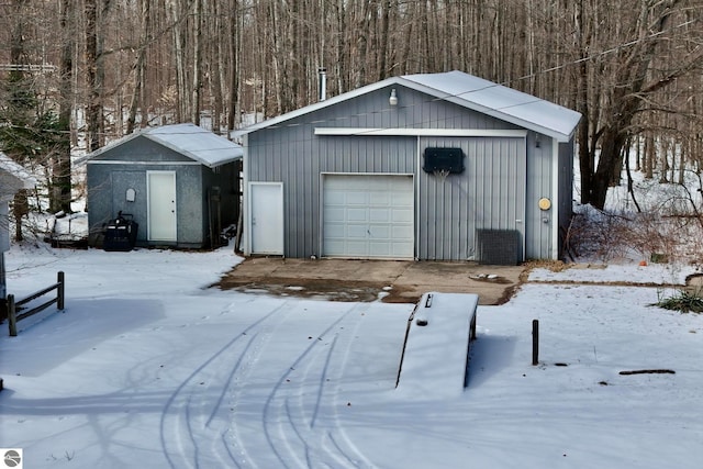 snow covered structure with a garage