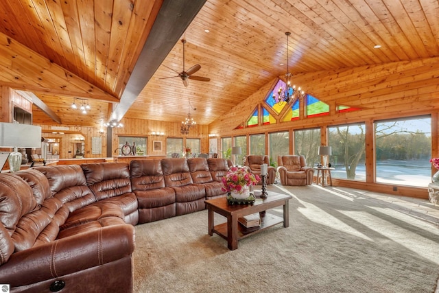 carpeted living room featuring ceiling fan with notable chandelier, high vaulted ceiling, wood ceiling, and wooden walls