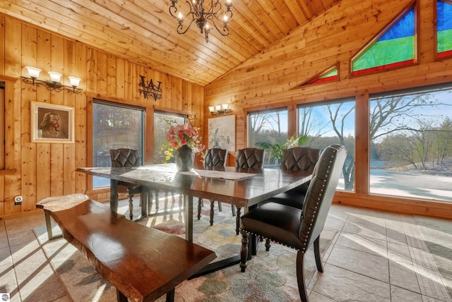 tiled dining space with wood ceiling, high vaulted ceiling, a notable chandelier, and wood walls