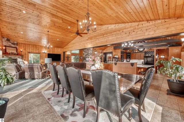 dining area featuring light tile patterned flooring, high vaulted ceiling, ceiling fan with notable chandelier, wooden ceiling, and wooden walls