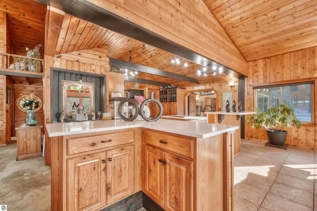 kitchen featuring light colored carpet, wooden walls, vaulted ceiling with beams, and wooden ceiling