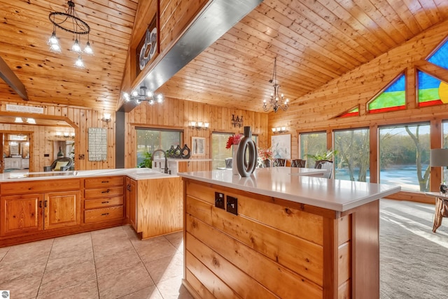 kitchen featuring wooden walls, an island with sink, and wood ceiling