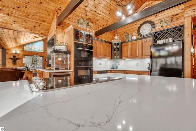 kitchen featuring wood walls, lofted ceiling with beams, sink, black appliances, and wooden ceiling