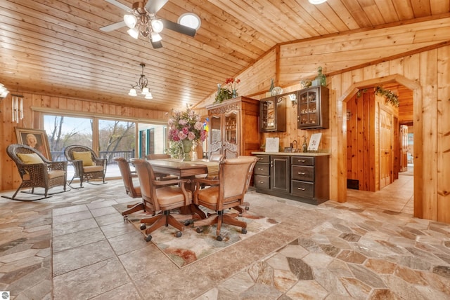 tiled dining area with ceiling fan, vaulted ceiling, wood ceiling, and wooden walls