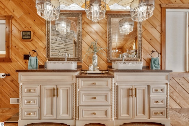 bathroom featuring wooden walls, an inviting chandelier, and vanity