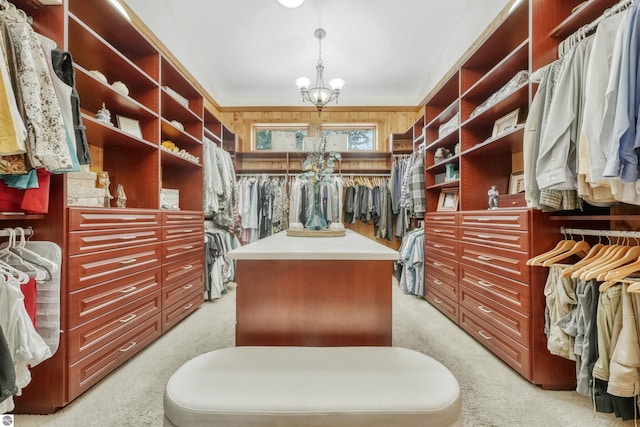 spacious closet with a notable chandelier and light colored carpet