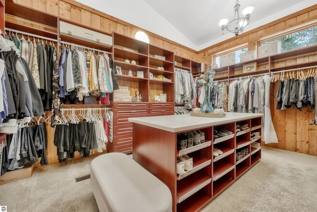 spacious closet with vaulted ceiling, a chandelier, and light colored carpet