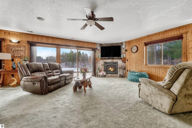 carpeted living room with a wealth of natural light and wooden walls