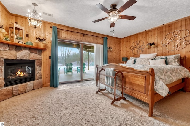 carpeted bedroom with a fireplace, wood walls, and a textured ceiling