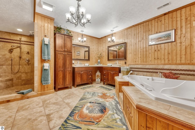 bathroom featuring shower with separate bathtub, vanity, a textured ceiling, wooden walls, and a notable chandelier