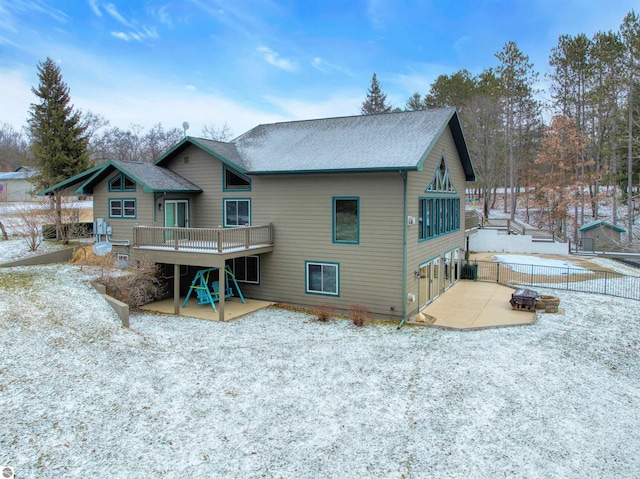 snow covered property with a deck and a patio