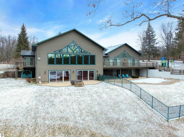 rear view of property featuring a wooden deck and a patio