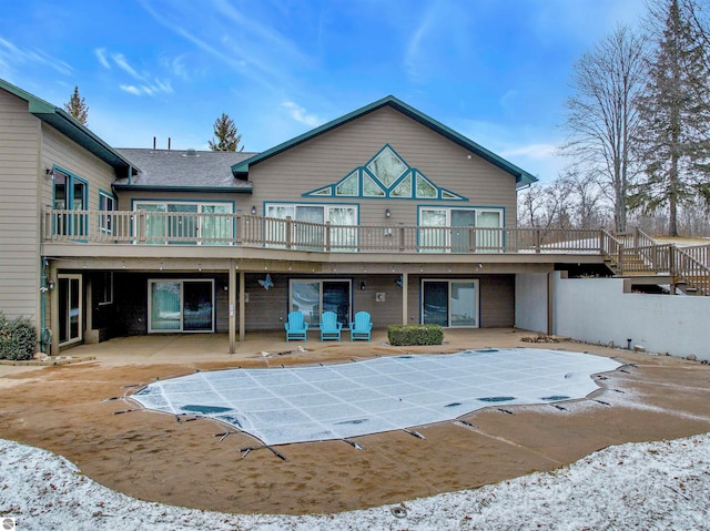 rear view of property with a deck and a patio