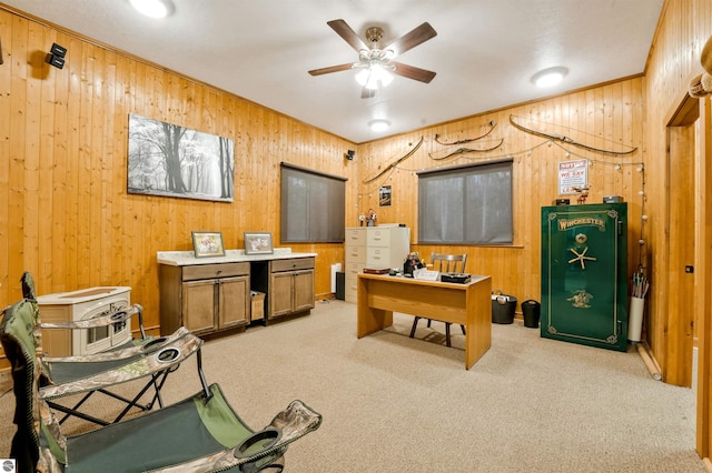 office area with ceiling fan, wooden walls, and light carpet