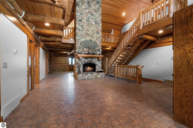 unfurnished living room with wood ceiling, a fireplace, high vaulted ceiling, and rustic walls