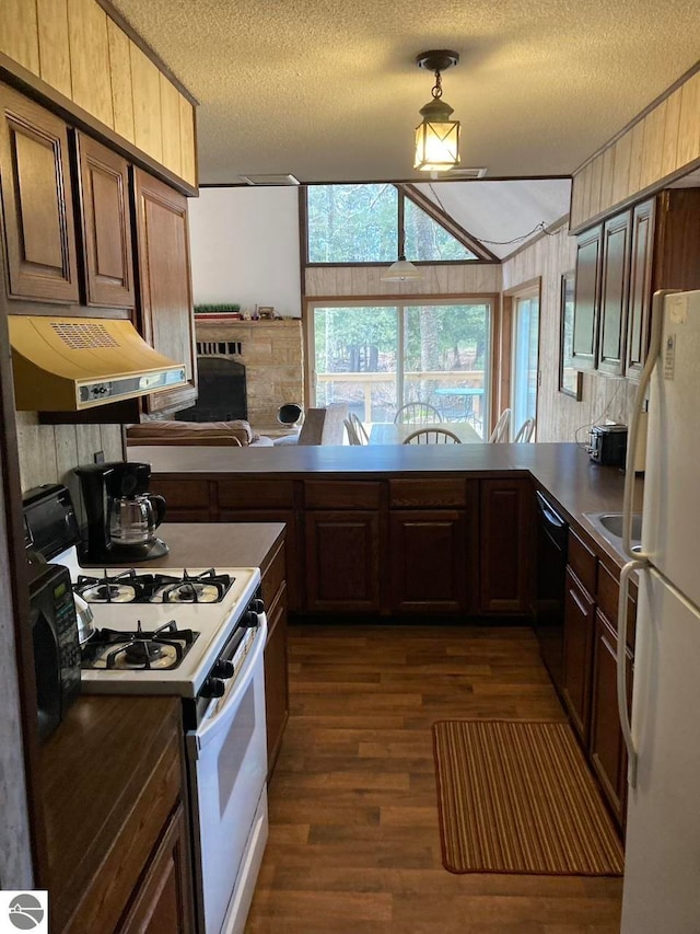 kitchen featuring white appliances, dark wood-type flooring, premium range hood, and a textured ceiling