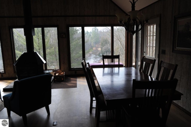 dining area with wood walls and a chandelier