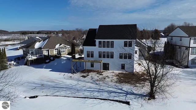 view of snow covered back of property