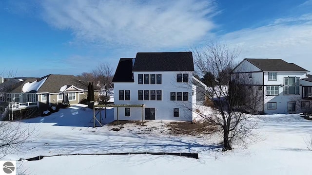 view of snow covered rear of property