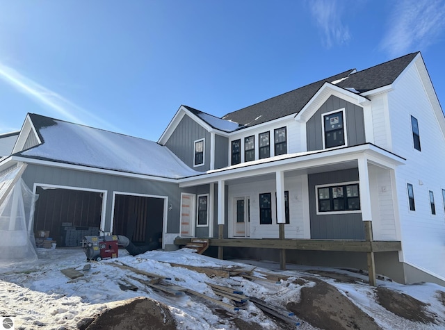 modern inspired farmhouse featuring a porch, board and batten siding, and an attached garage