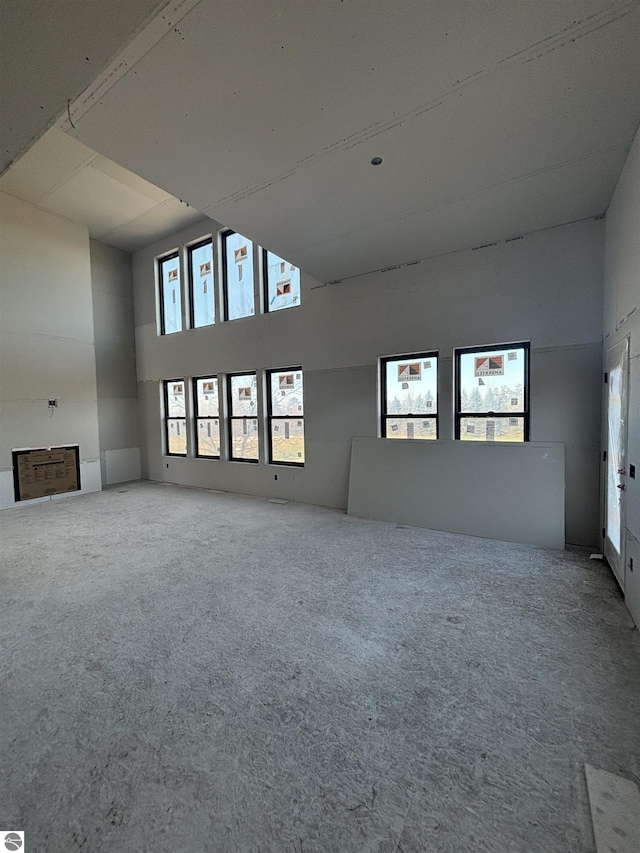 unfurnished living room with a high ceiling and carpet