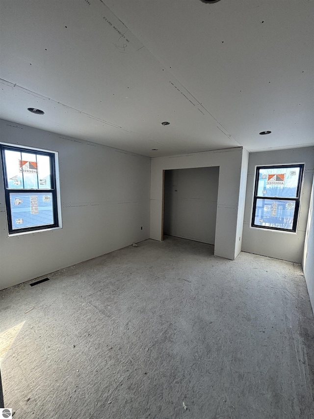 unfurnished room with plenty of natural light and visible vents