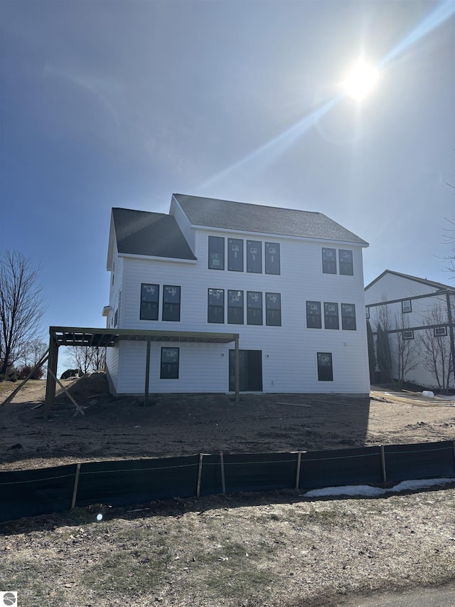 back of property with an attached carport