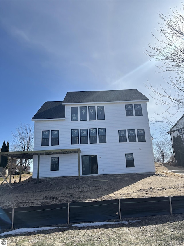 back of house featuring a carport