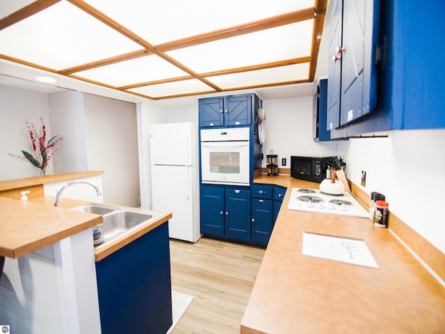 kitchen with white appliances, blue cabinets, tasteful backsplash, and light hardwood / wood-style flooring