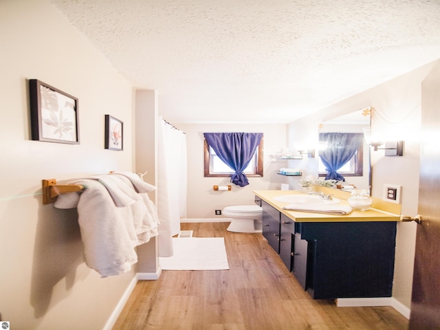 bathroom with toilet, a textured ceiling, vanity, and hardwood / wood-style flooring