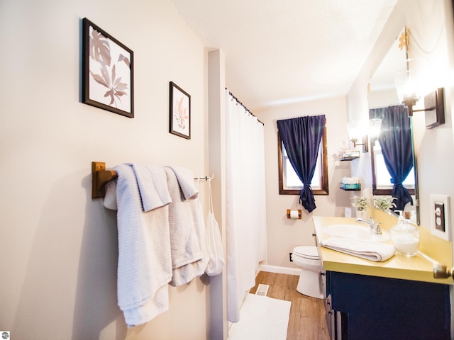 bathroom with oversized vanity, hardwood / wood-style floors, and toilet