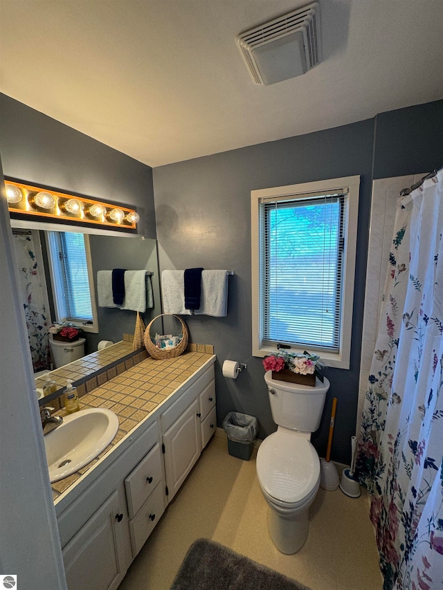 bathroom with toilet, walk in shower, and vanity