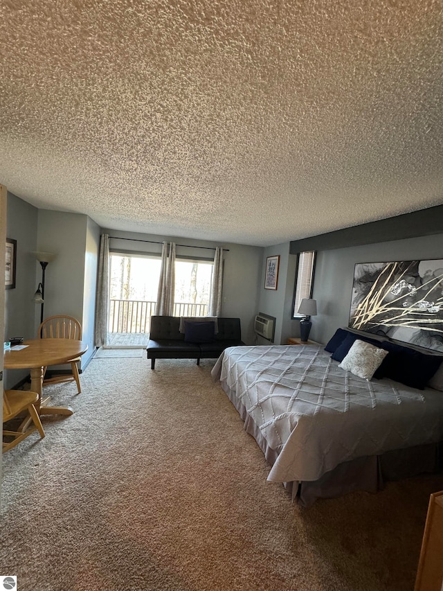 carpeted bedroom featuring an AC wall unit and a textured ceiling