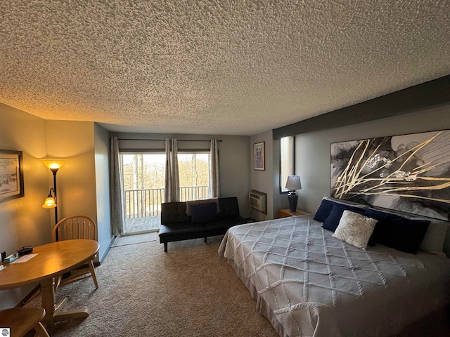 carpeted bedroom featuring access to outside, a textured ceiling, and a wall mounted air conditioner