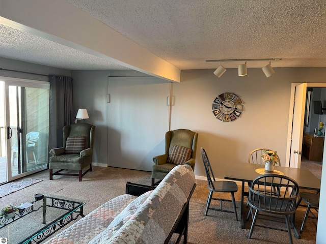 living room with dark carpet, a textured ceiling, and rail lighting