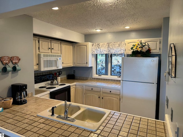 kitchen featuring tile counters, a textured ceiling, sink, and white appliances