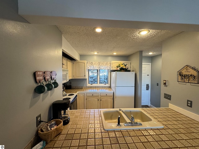 kitchen featuring tile countertops, sink, a textured ceiling, and white appliances