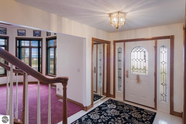 foyer featuring a textured ceiling and a notable chandelier