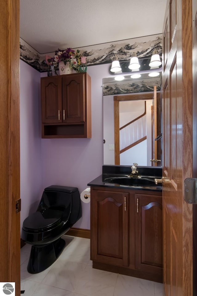 bathroom featuring toilet, tile flooring, and vanity