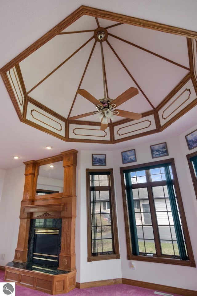 interior space featuring a fireplace, carpet floors, and ceiling fan