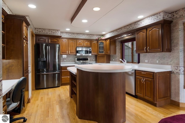 kitchen featuring a center island, backsplash, appliances with stainless steel finishes, light hardwood / wood-style floors, and dark brown cabinetry