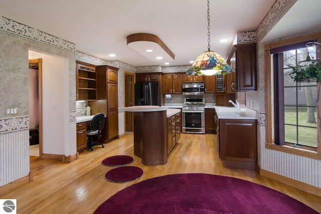 kitchen featuring appliances with stainless steel finishes, a center island, light hardwood / wood-style floors, tasteful backsplash, and hanging light fixtures