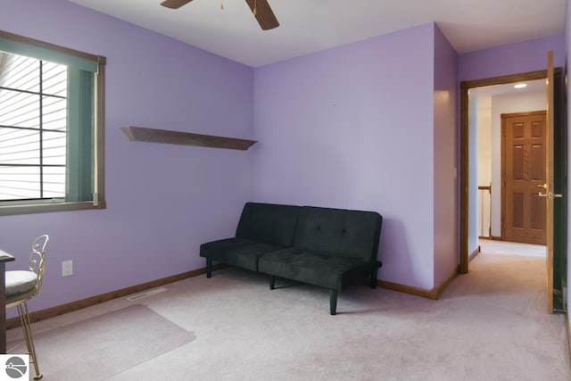 sitting room featuring light colored carpet and ceiling fan