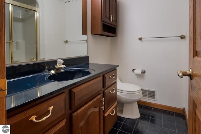 bathroom with tile floors, vanity, and toilet