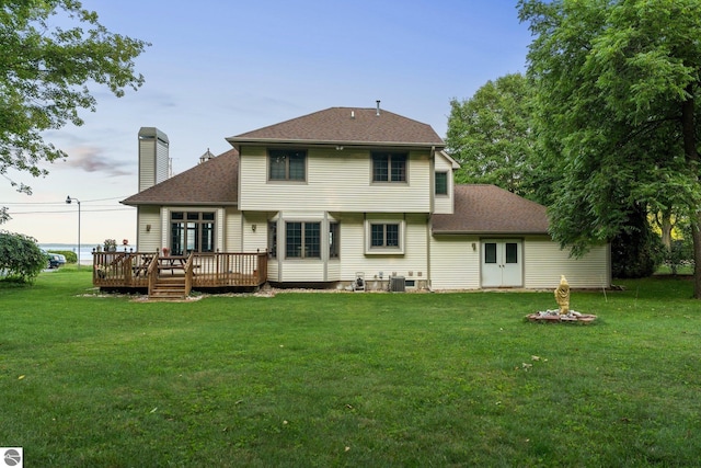 back of house with a wooden deck and a lawn