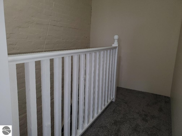 hallway with dark colored carpet