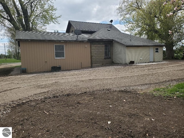 back of house with central AC unit