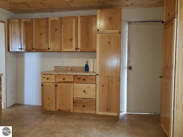 kitchen with wooden ceiling and concrete flooring