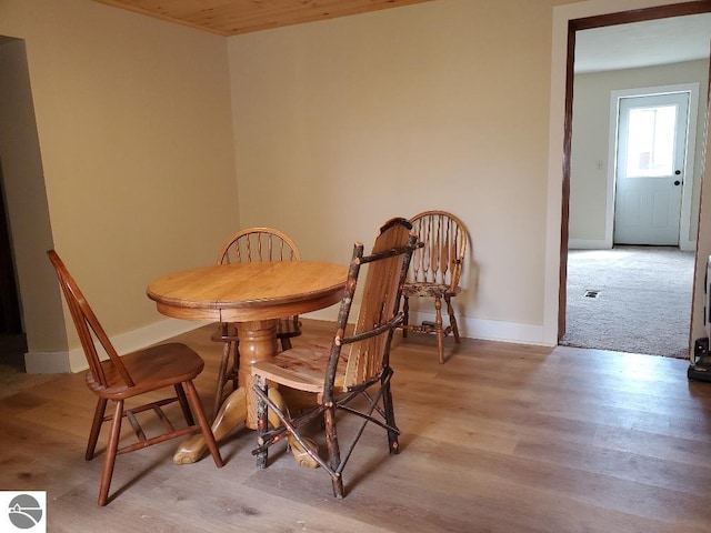 carpeted dining area featuring wooden ceiling