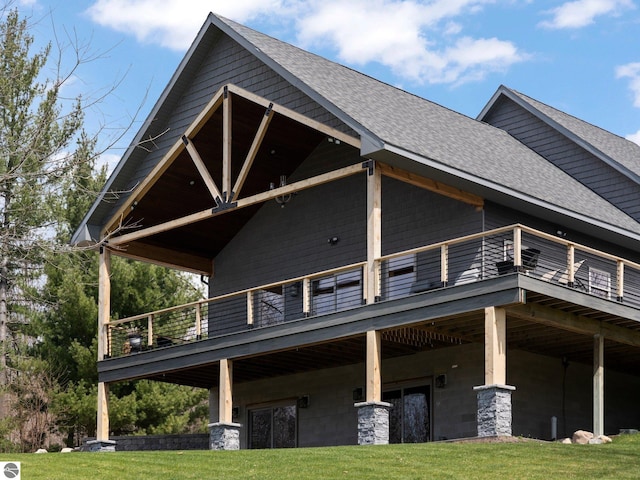 back of house featuring a yard and a balcony